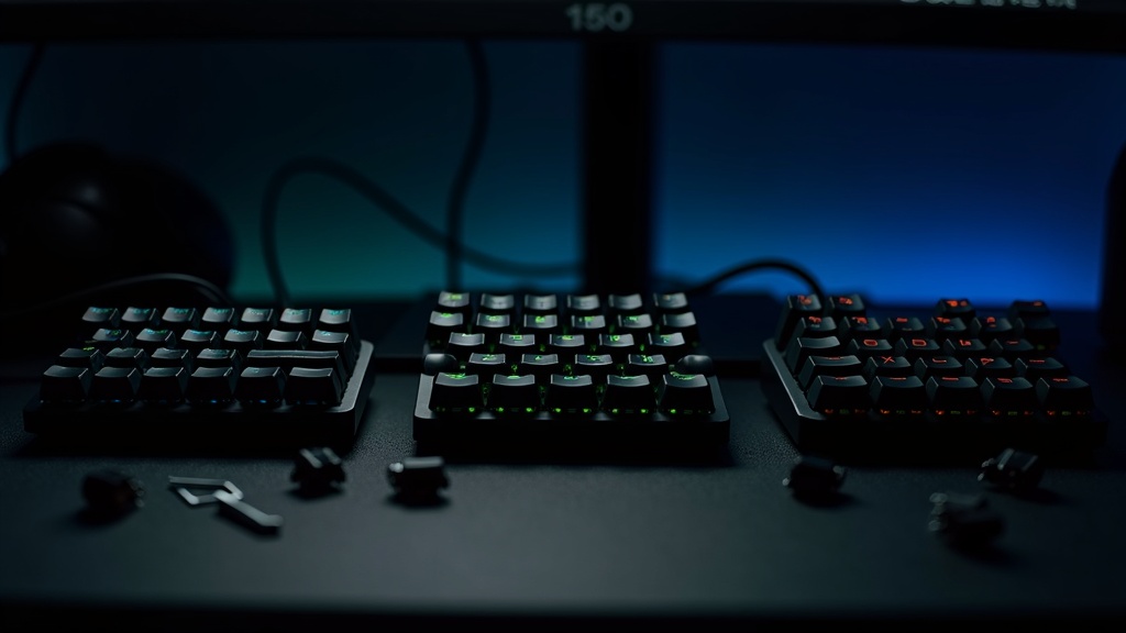 緑色に光る3台のゲーミングキーボードとホットスワップ用キースイッチを並べた比較風景