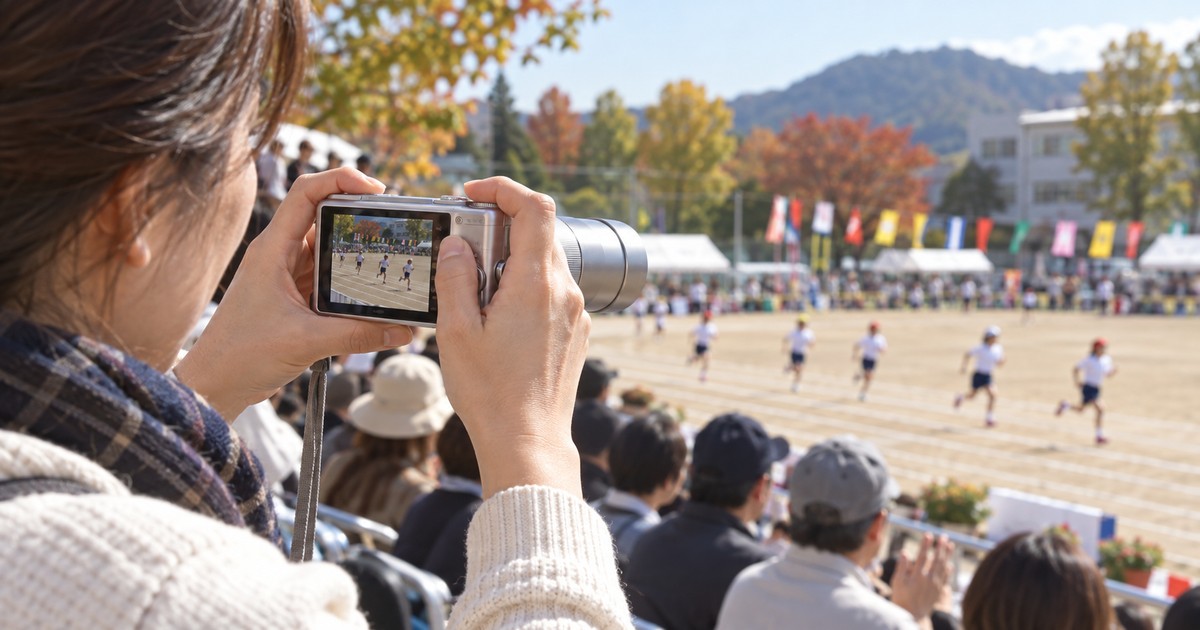 運動会で小型1型ズームコンデジの望遠を使って遠くの子どもを撮影する親